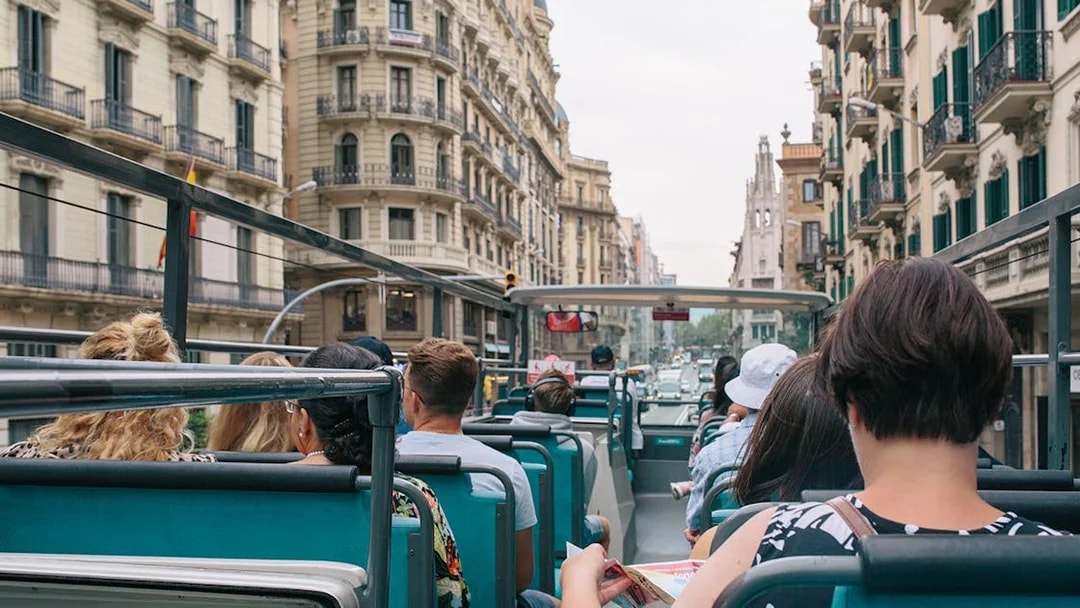Tourists on an open-top bus touring Barcelona with Hola Barcelona Travel Card.
