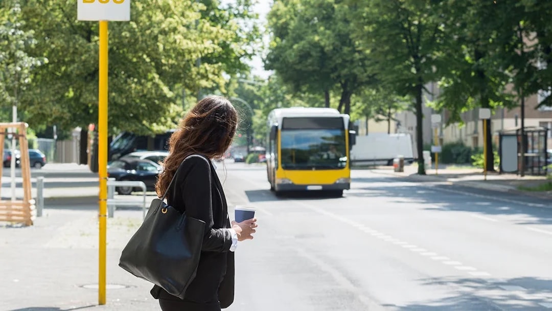 Tourist waiting at a bus stop in Barcelona with Hola Barcelona Travel Card.