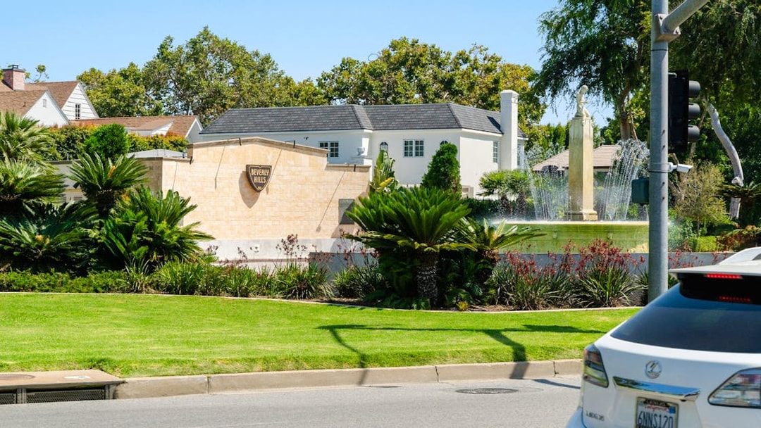 Electric Fountain at Beverly Gardens Park, Beverly Hills, with surrounding greenery and nearby homes.
