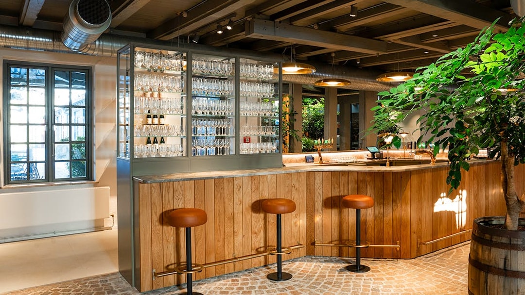 Bar area with stools and glassware display inside Home of Carlsberg exhibit.