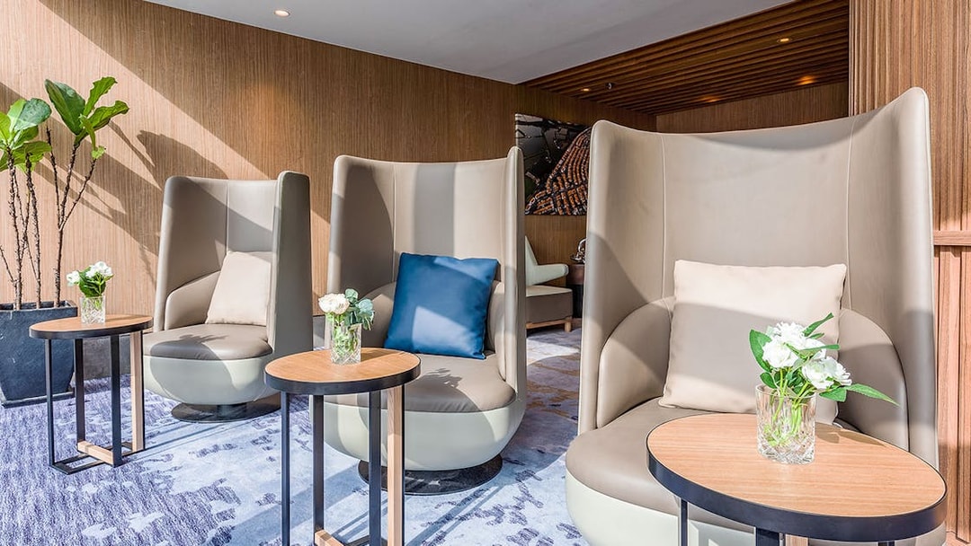 Plaza Premium Lounge seating area with modern chairs and small tables.