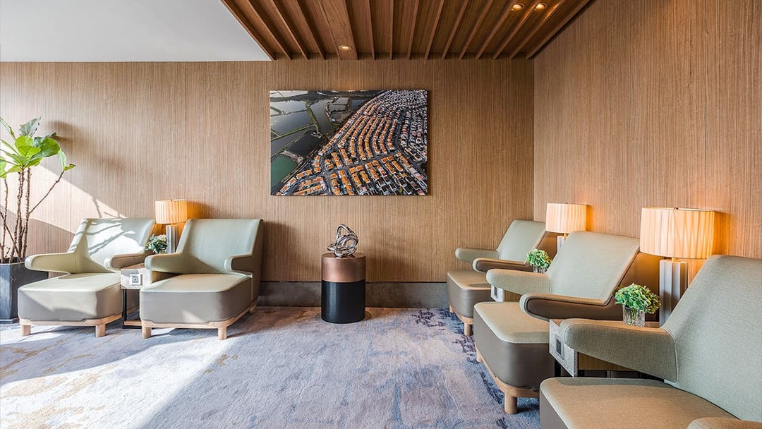 Seating area in Plaza Premium Lounge with modern chairs and wall art.