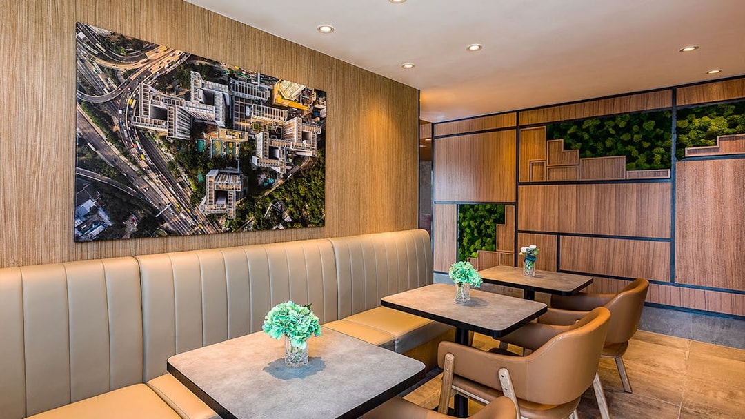 Seating area in Plaza Premium Lounge with aerial cityscape artwork on the wall.