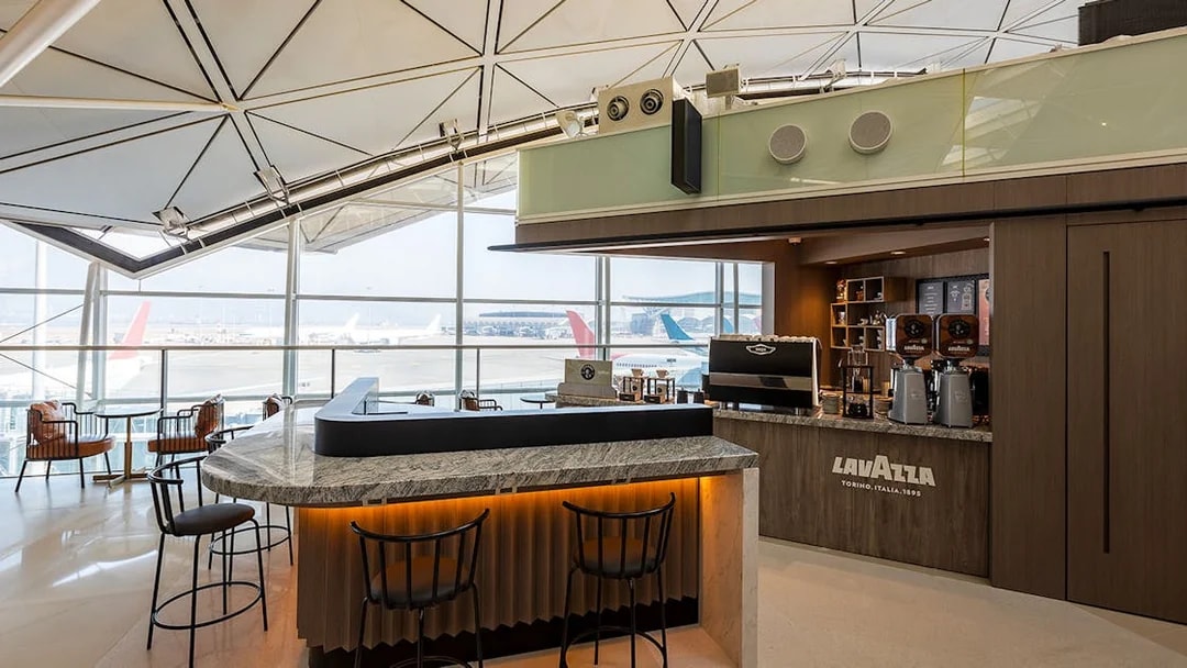 Plaza Premium Lounge coffee bar with airport runway view.