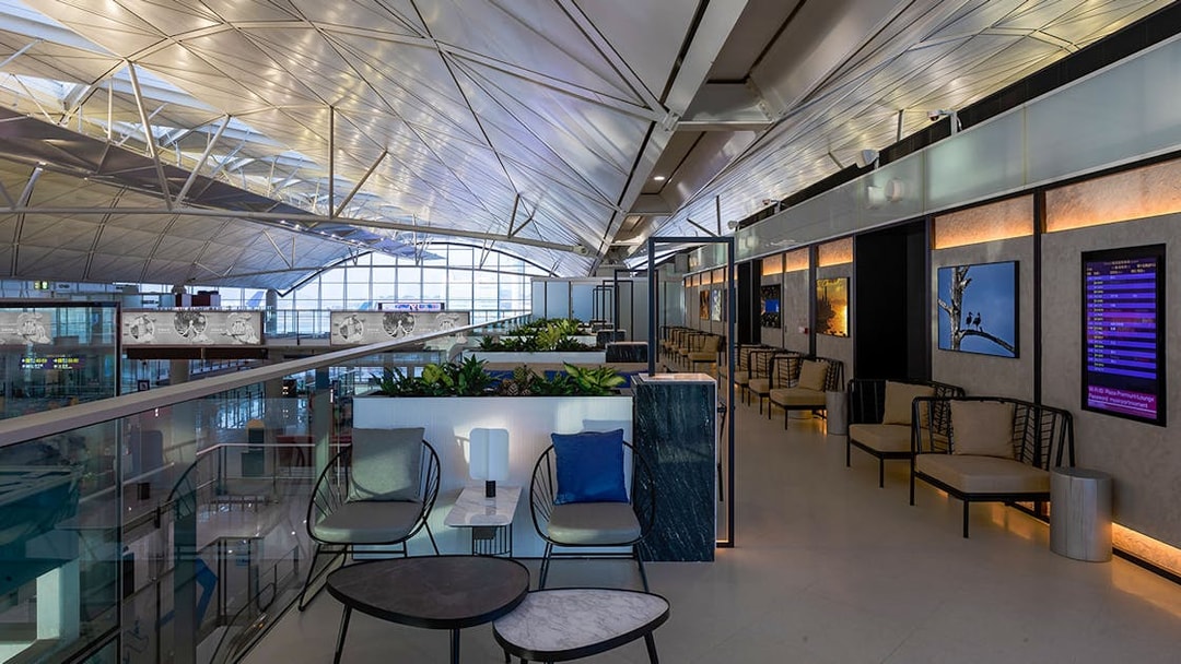 Plaza Premium Lounge seating area with modern decor and flight information display.