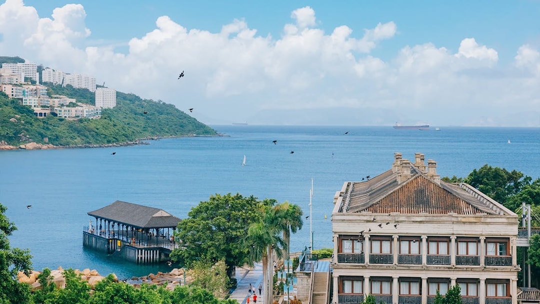 Seaside view with historic building and pier on Big Bus Hop-On Hop-Off Tour route.