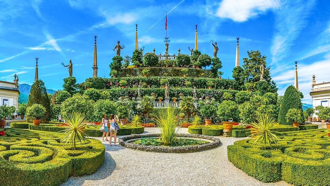 Isola Bella garden with statues and tourists, part of the Hop-on Hop-off Isole Borromee tour.