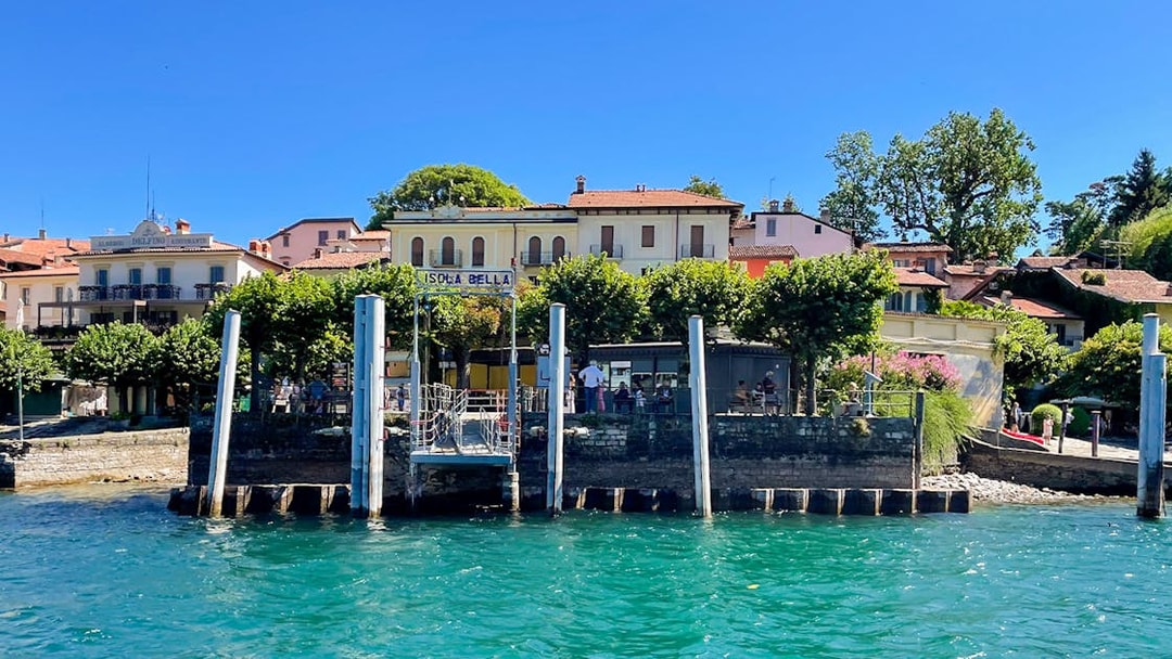 Isola Bella dock with buildings and trees, part of the Hop-on Hop-off Isole Borromee tour.