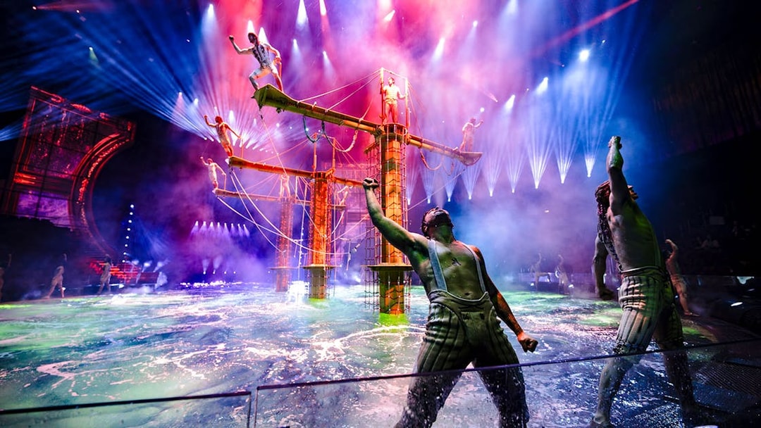 Acrobats performing on water stage during House of Dancing Water show.