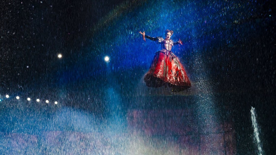 Performer suspended in air during House of Dancing Water show.