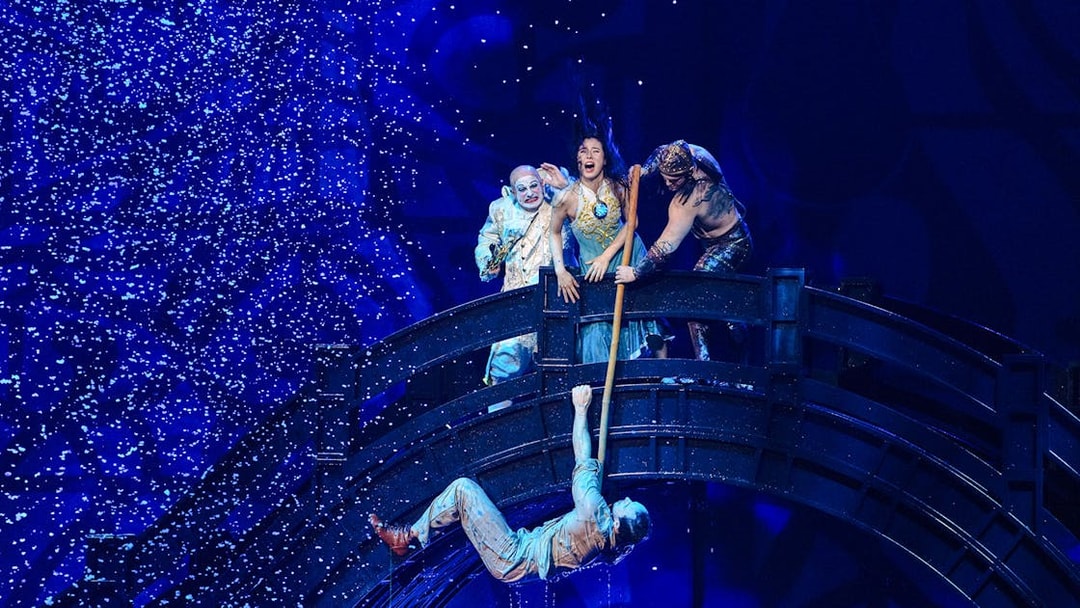 Performers on a bridge during House of Dancing Water show, with one hanging below.