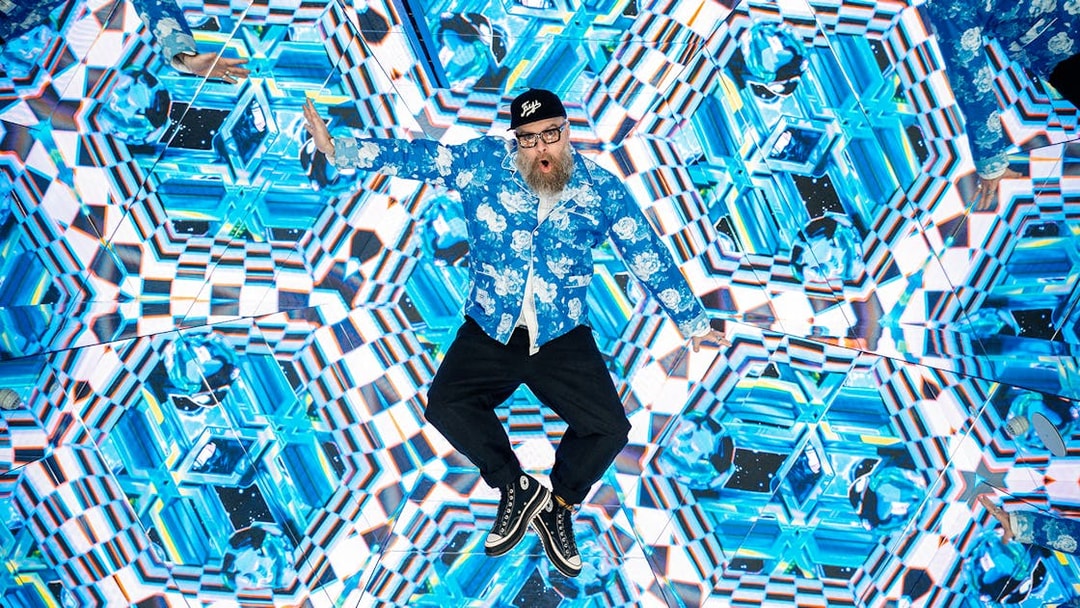 Tourist engaging with kaleidoscopic display at House of Hype interactive experience.