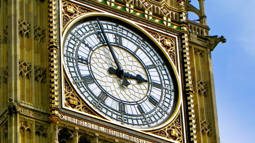 Close-up of Big Ben clock face in London, showing Roman numerals and ornate details.
