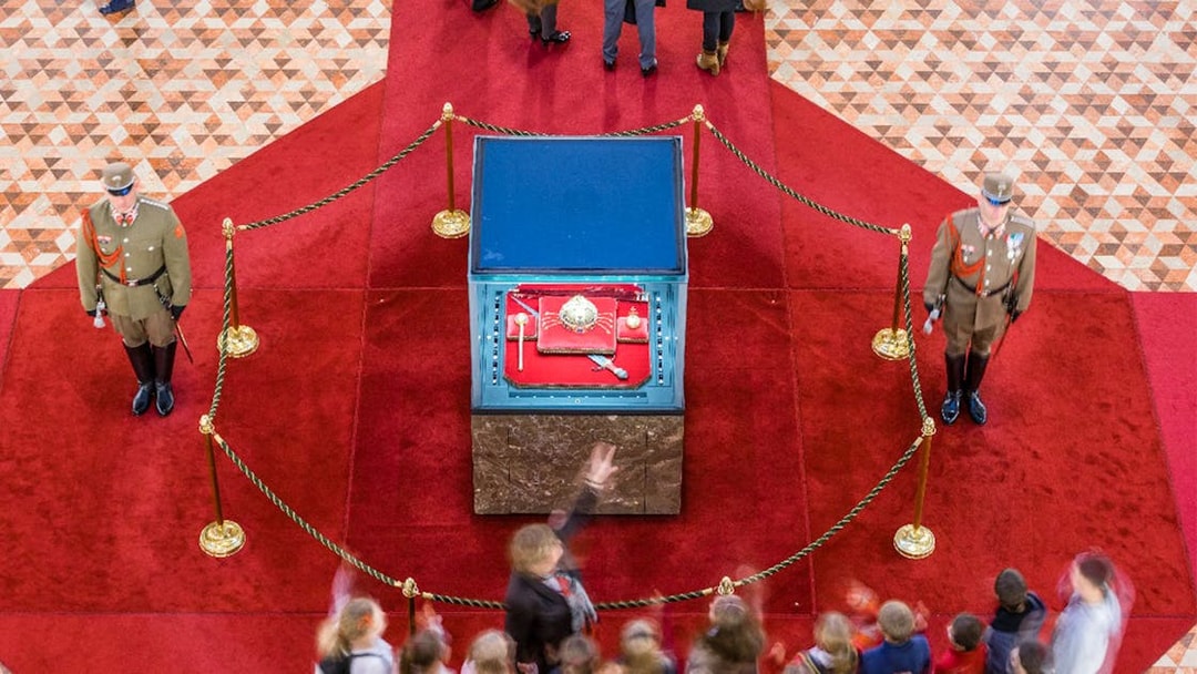 Hungarian Parliament crown jewels display with guards and visitors in Budapest.