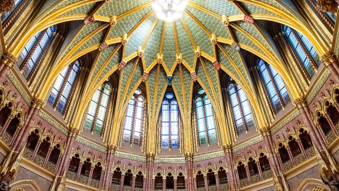 Ceiling of the Dome Hall in the Hungarian Parliament, Budapest, featuring ornate arches and stained glass.