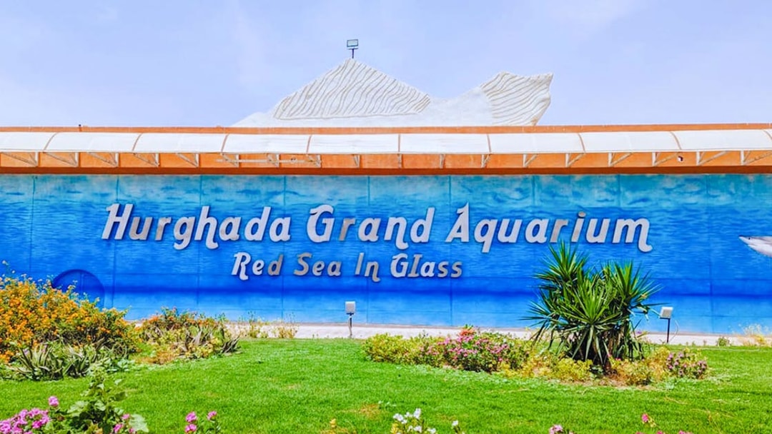 Hurghada Grand Aquarium entrance with garden and signage.