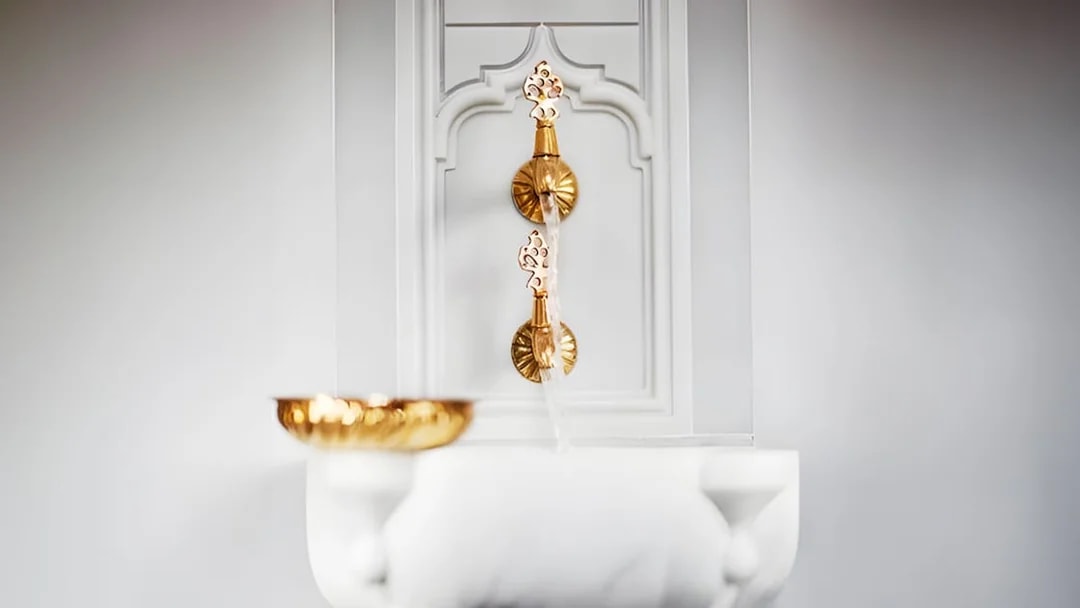 Golden taps and marble basin in Hurrem Sultan Hamam, Istanbul.