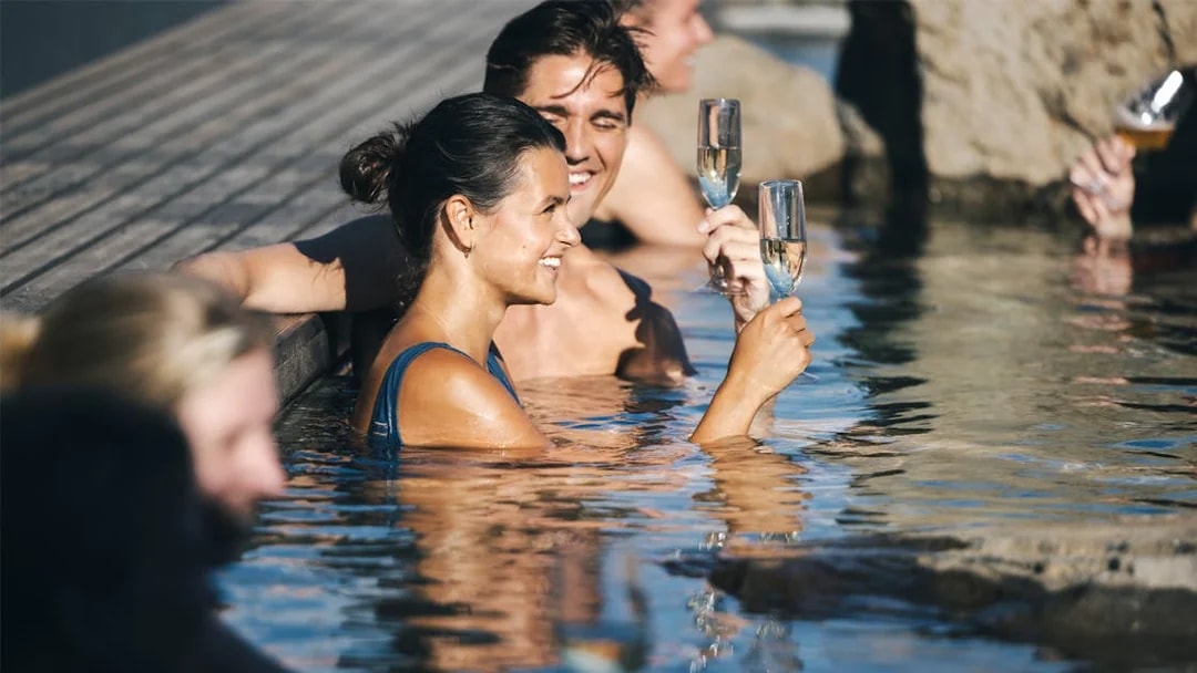 People enjoying drinks in Hvammsvík Hot Spring near Reykjavík.