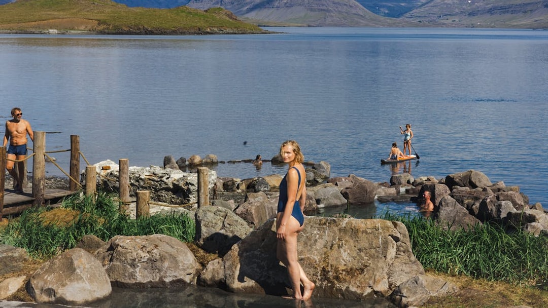 Hvammsvík Hot Spring visitors enjoying geothermal pools and paddleboarding near Reykjavík.