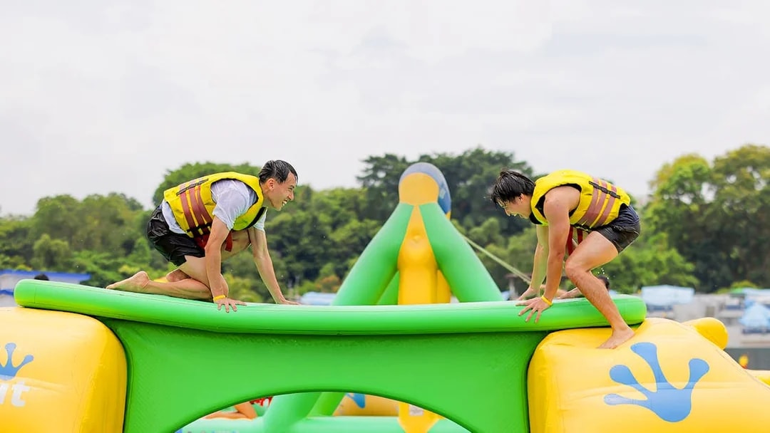 Participants balancing on inflatable obstacle at HydroDash Singapore.