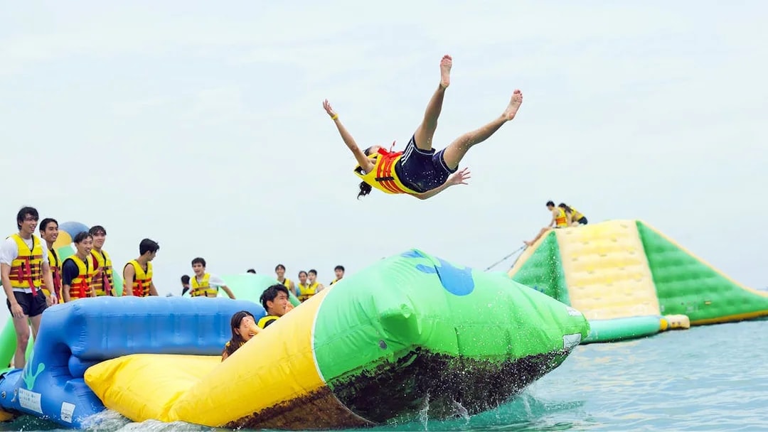 Girl bouncing off inflatable mat at HydroDash water park, Singapore.