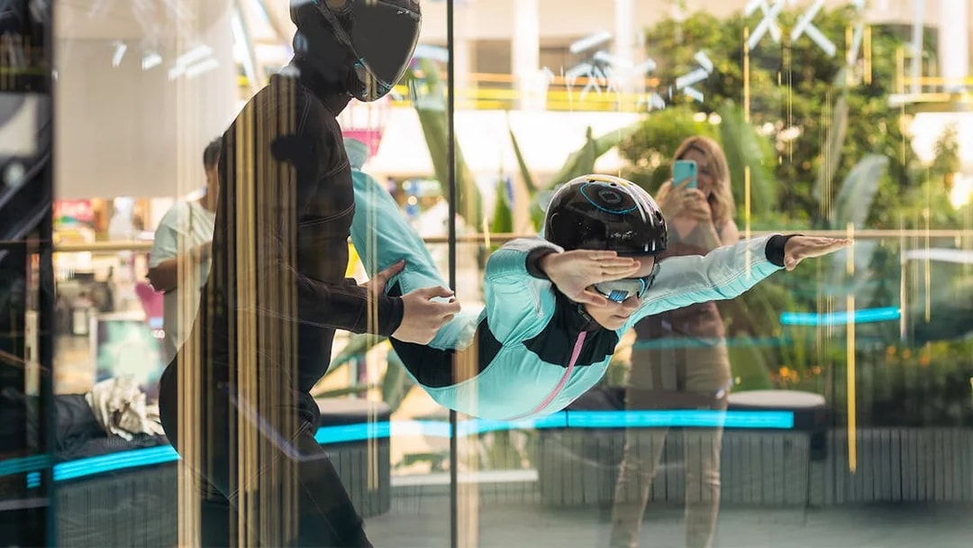 Young girl with instructor in iFly Dubai indoor skydive experience.