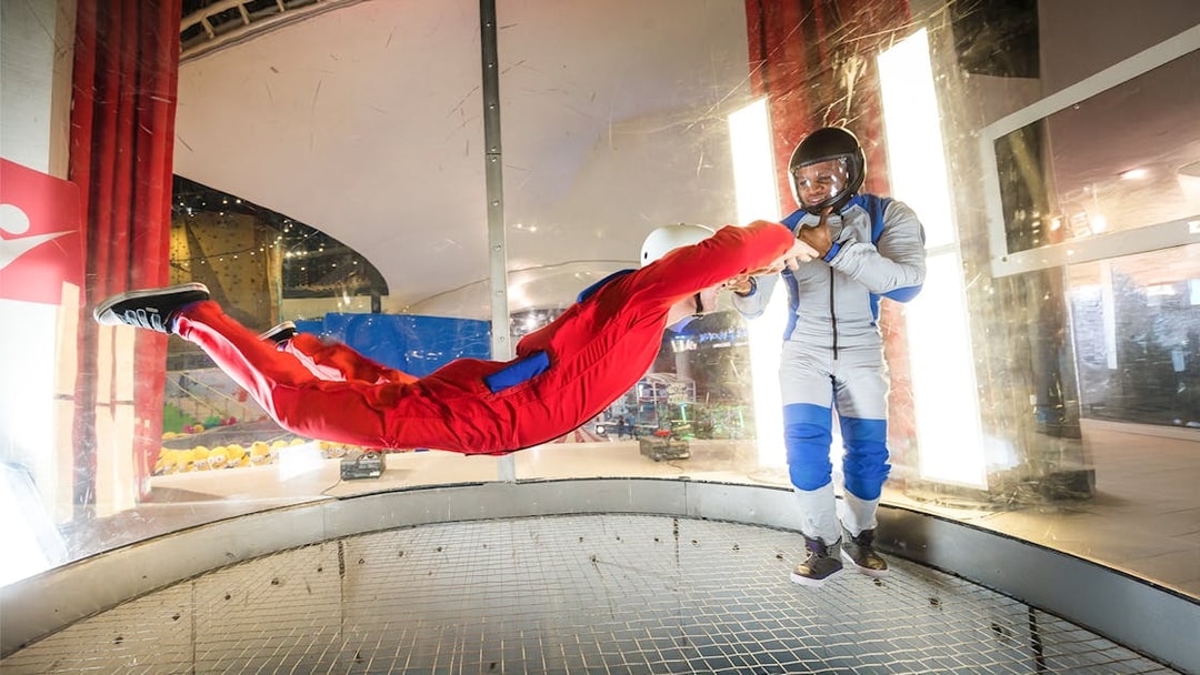 Person skydiving indoors with instructor at iFly Dubai.