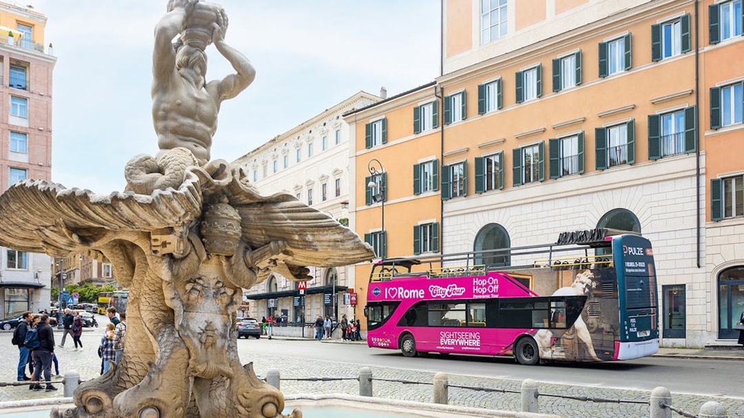Triton Fountain with I Love Rome hop-on hop-off tour bus in Rome, Italy.