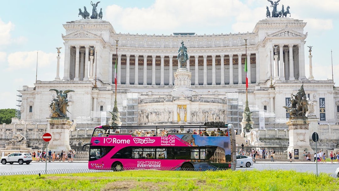 Hop-on hop-off tour bus in front of the Altare della Patria in Rome.