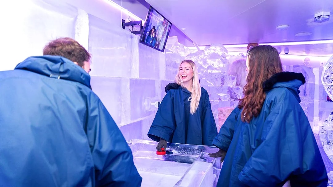 Visitors enjoying games at IceBar Surfers Paradise, surrounded by ice sculptures.