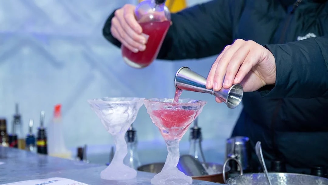 Bartender pouring red cocktail into ice glasses at IceBar Surfers Paradise.