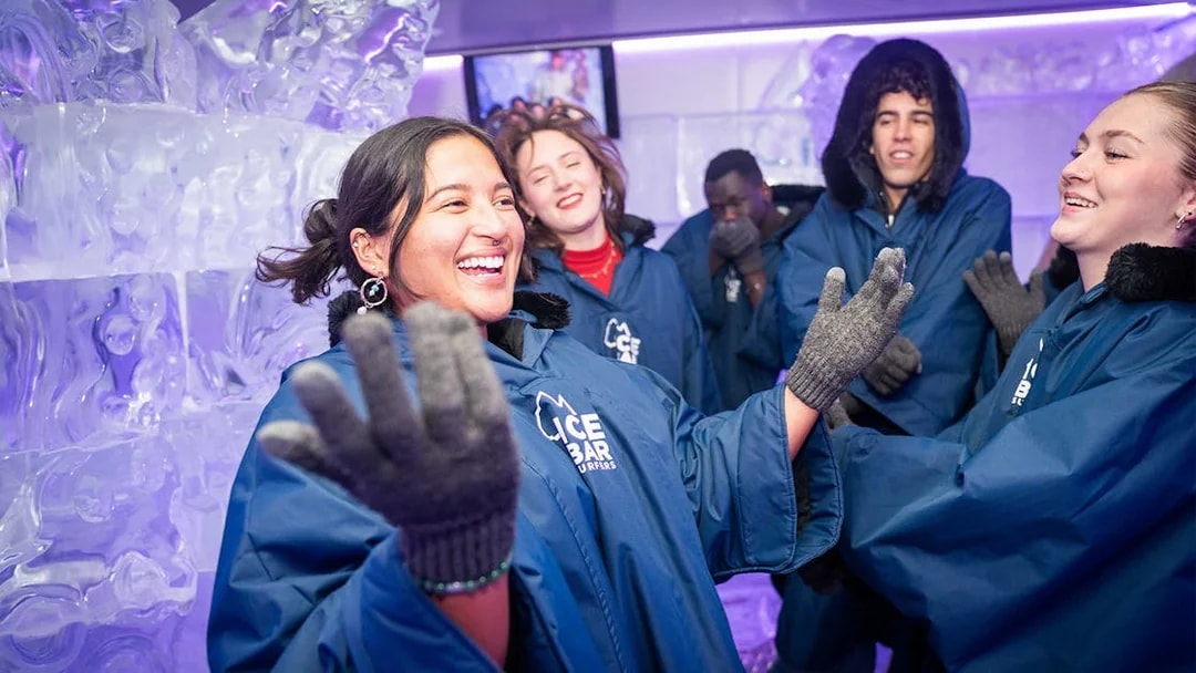 Visitors enjoying IceBar Surfers Paradise in winter coats and gloves.