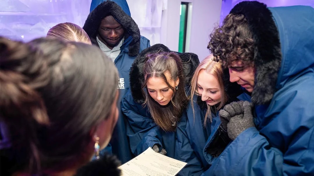 Group in winter coats reading a menu at IceBar Surfers Paradise.