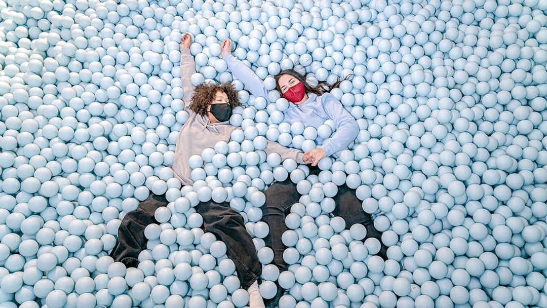 Visitors enjoying a ball pit at Ikono in Madrid.