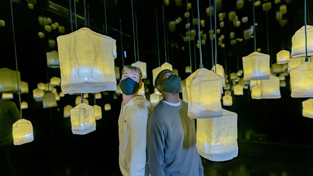 Visitors exploring illuminated lanterns at Ikono in Madrid.