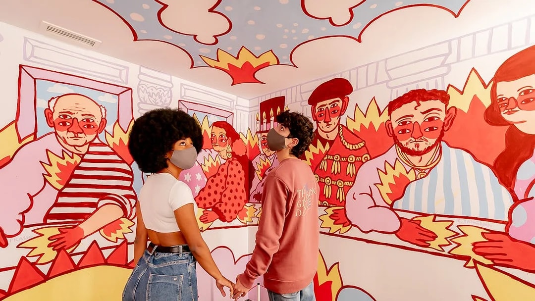 Couple exploring colorful mural at Ikono in Madrid.