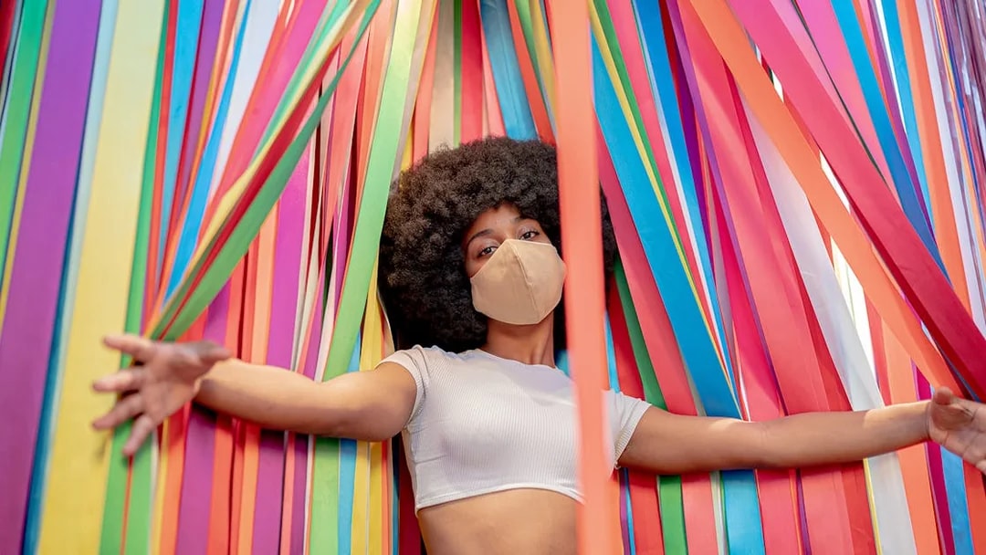 Person standing among colorful ribbons at Ikono in Madrid.
