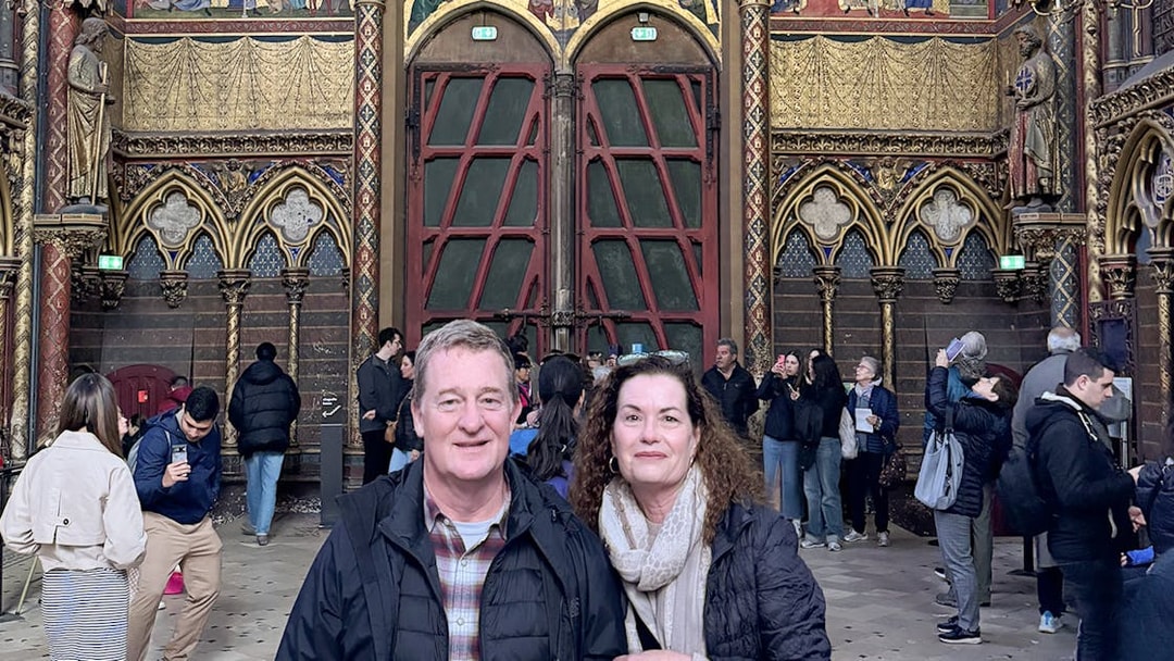 Visitors inside Sainte Chapelle, Paris, admiring the ornate interior and stained glass.