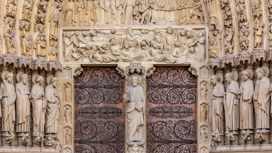 Notre Dame Cathedral facade with detailed sculptures, Paris.