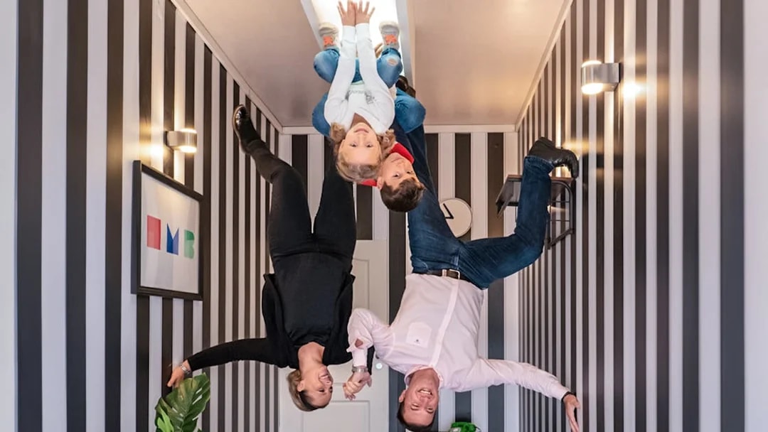 Visitors experiencing an upside-down room at Illuseum Berlin.