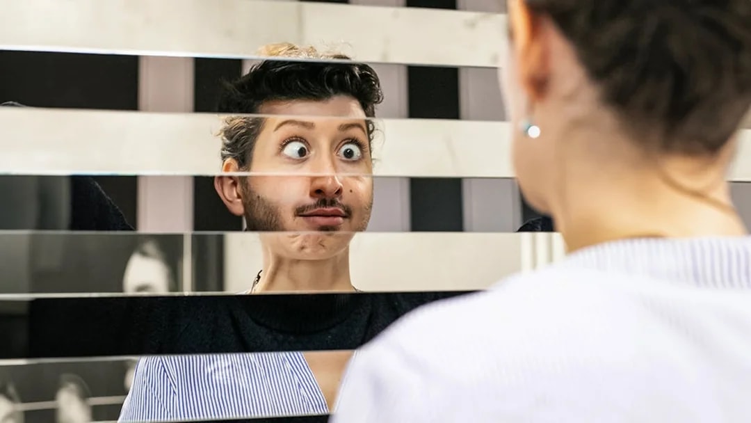 Person looking into a fragmented mirror at Illuseum Berlin.