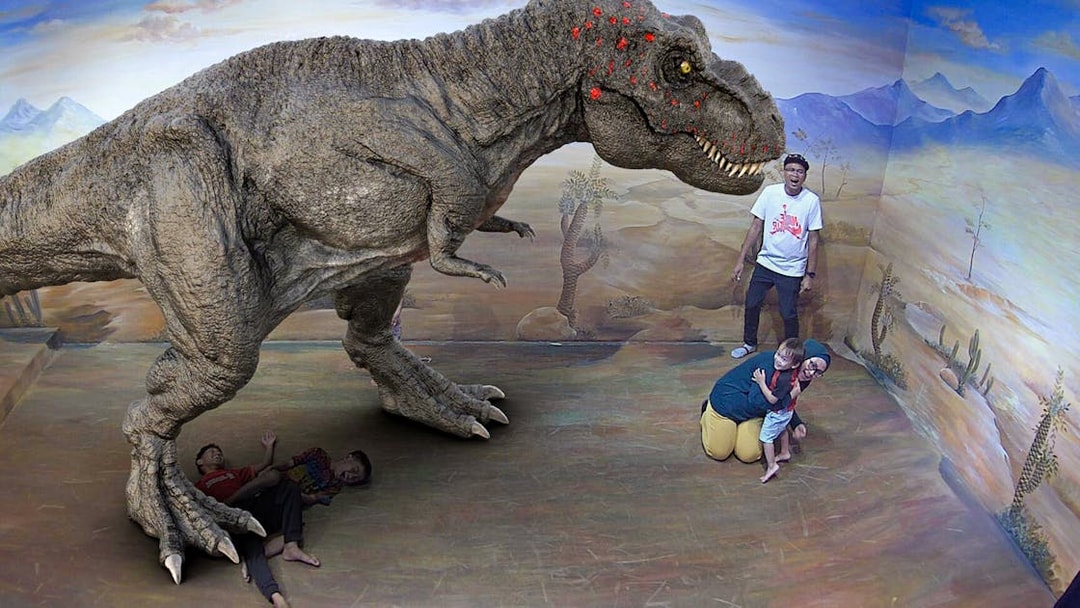 Visitors interacting with a 3D dinosaur illusion at Illusion 3D Art Museum Kuala Lumpur.