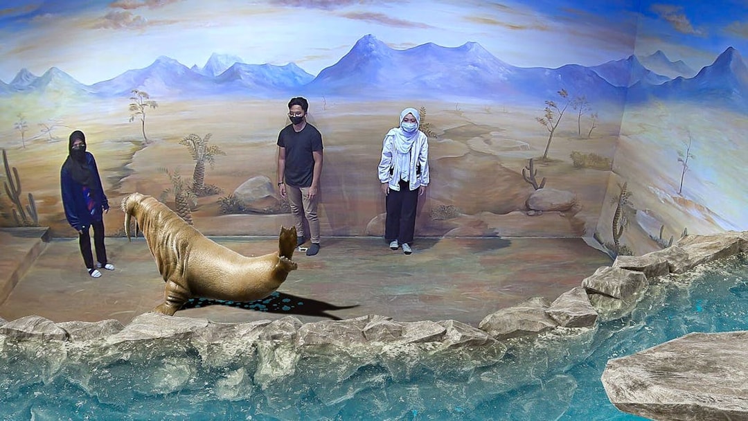 Visitors interact with 3D walrus art at Illusion 3D Art Museum Kuala Lumpur.