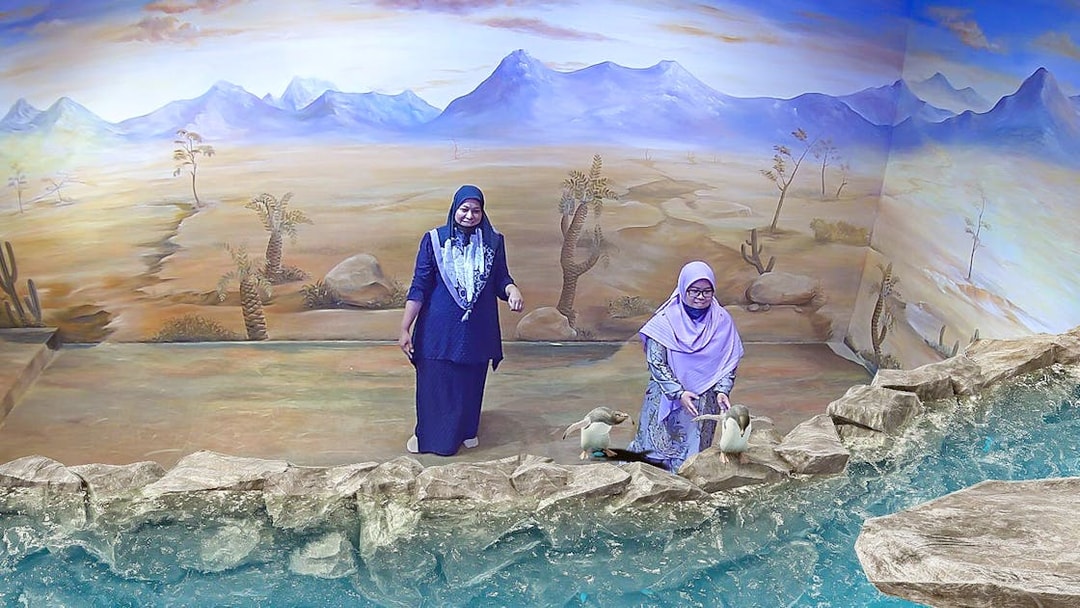 Visitors interacting with 3D penguin art at Illusion 3D Art Museum Kuala Lumpur.