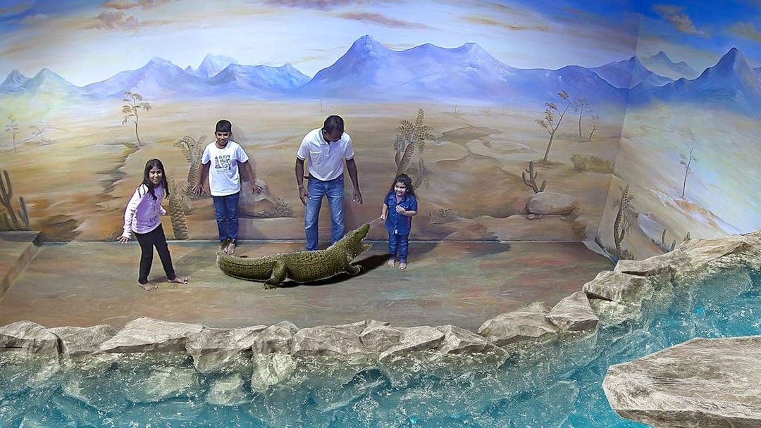 Visitors interact with 3D crocodile art at Illusion 3D Art Museum Kuala Lumpur.