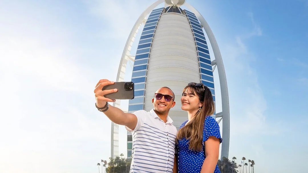 Visitors taking a selfie in front of Burj Al Arab, Dubai.