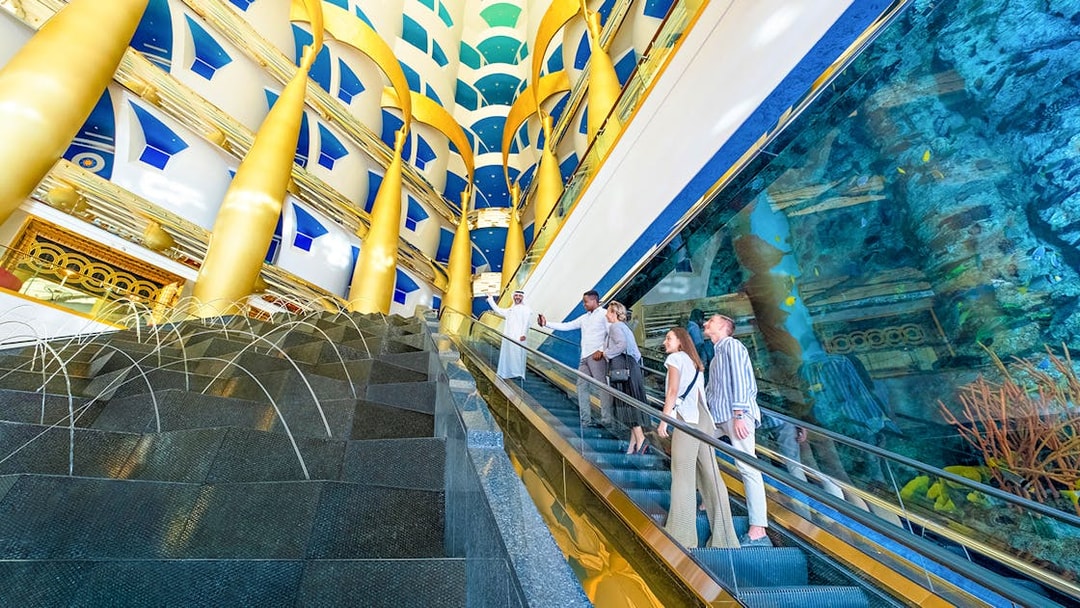 Visitors on an escalator during a guided tour inside Burj Al Arab, Dubai.