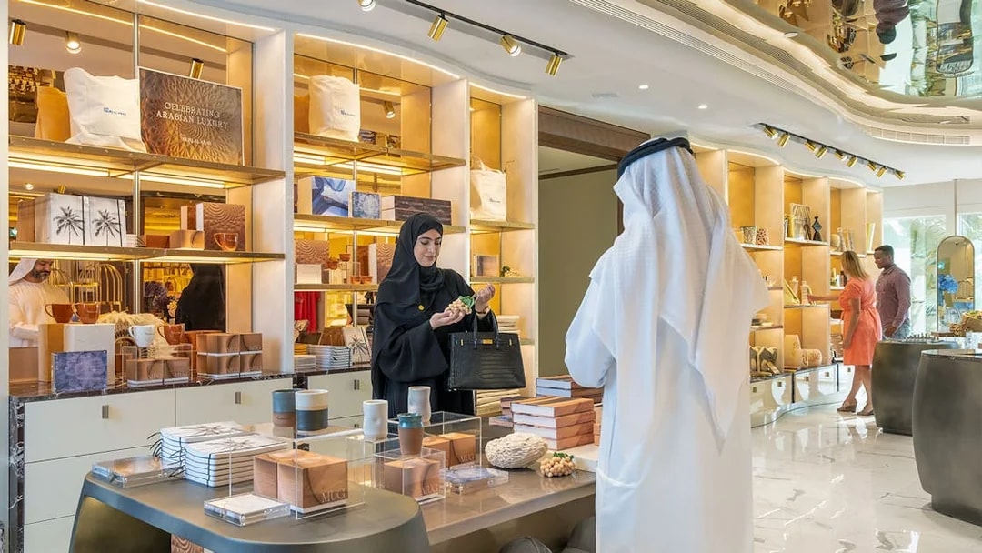Tourists exploring luxury items at UMA Lounge gift shop during Inside Burj Al Arab Tour in Dubai.