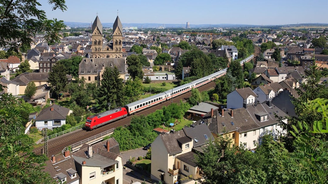Train passing through a German town with historic church in the background.