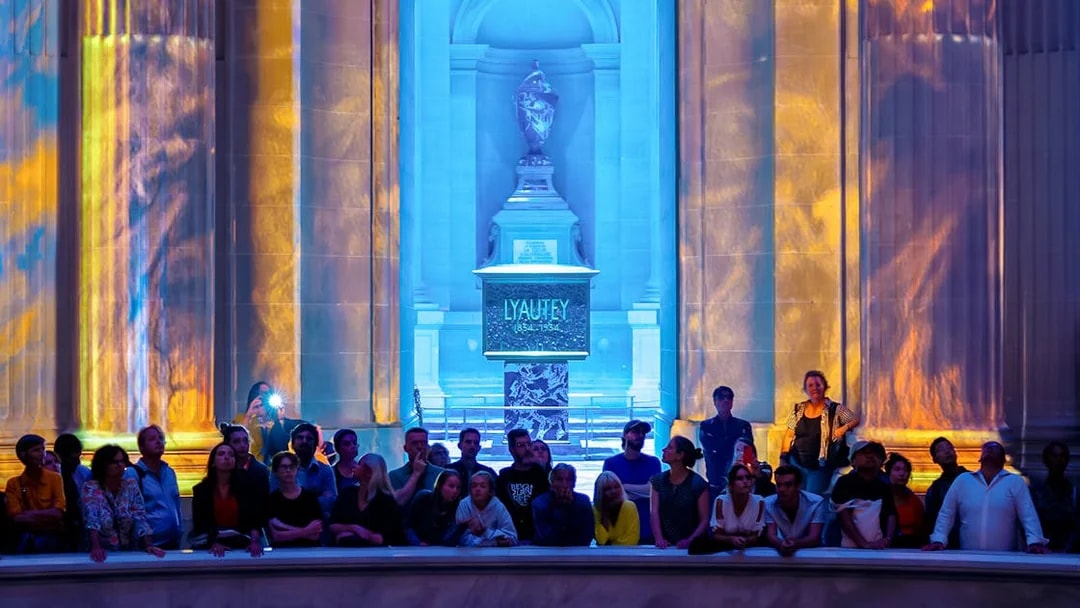 Audience at Aura Immersive show, Invalides stage with colorful light projections.